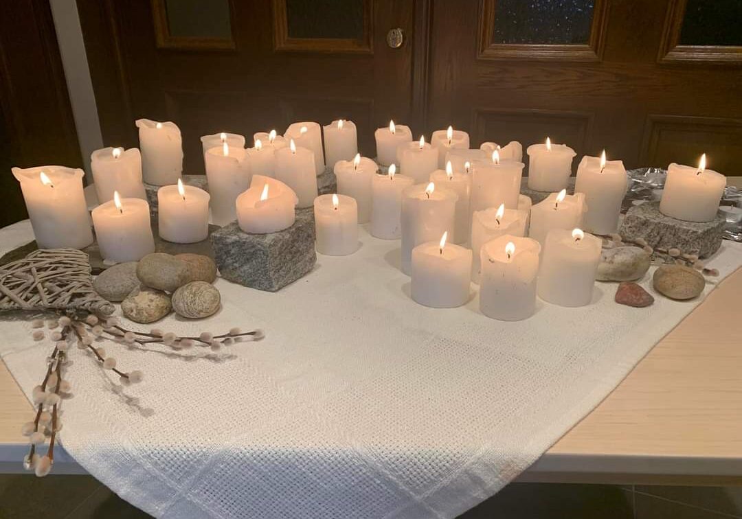 Et bord med mer enn 20 kubbelys som brenne til minne om de som har mistet livet i selvmord.